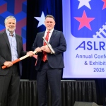 Matt Walsh hands Justin Broyles the ceremonial spike maul.