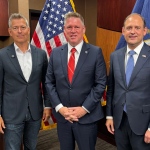 Justin Broyles stands with Andy Barr and Sean Duffy in front of the American and Kentucky flags.